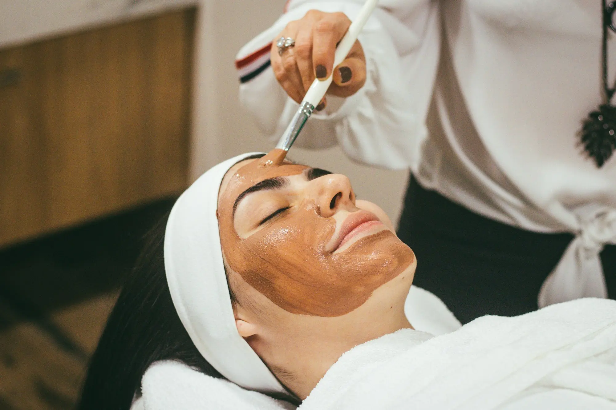 Profesional realizando una limpieza facial a una paciente